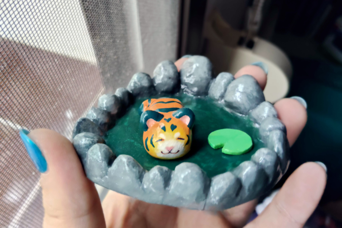 photo of a clay sculpture of a tiger chilling in a pond